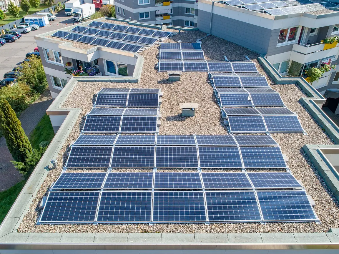 Solarmodule auf Flachdach eines Wohngebäudes für nachhaltige Energieerzeugung in städtischer Umgebung.