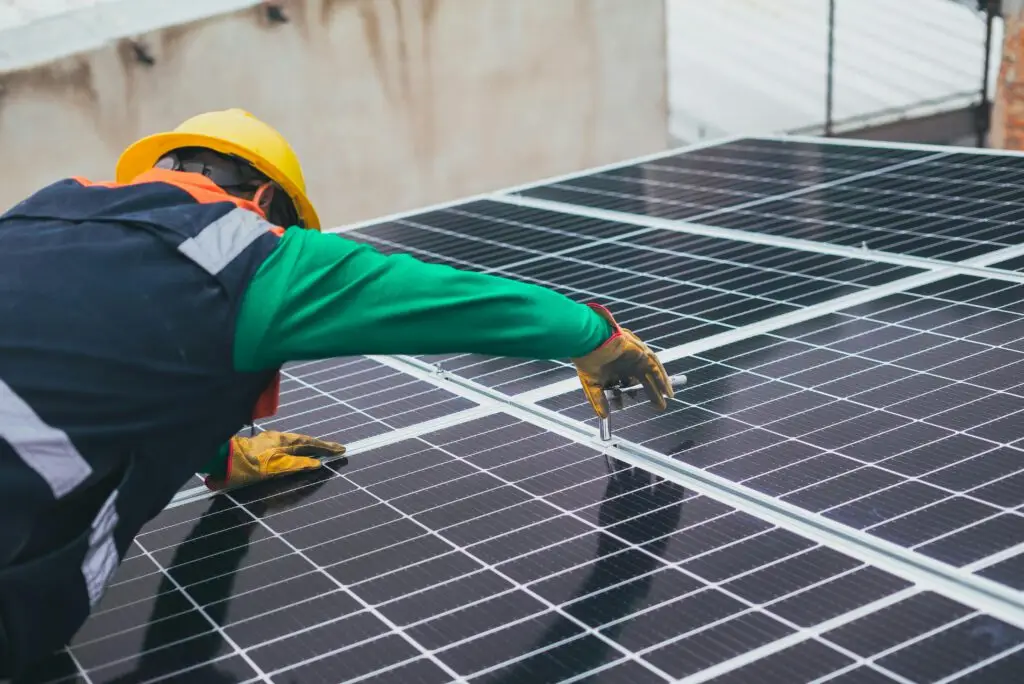 Ein Mann der ein Solarmodul installiert