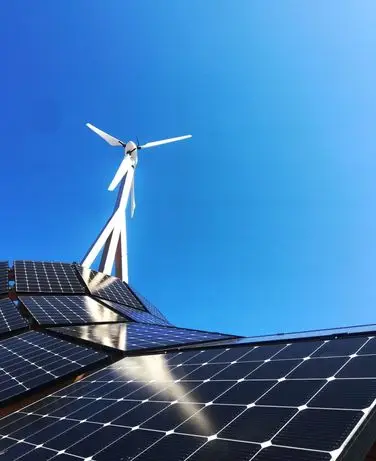 Solarpaneele und Windturbine unter klarem Himmel, Symbol für erneuerbare Energien und nachhaltige Stromerzeugung.