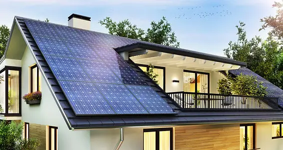 Modernes Haus mit Solaranlage auf dem Dach, umgeben von Bäumen, Sonnenenergie-Installation für nachhaltiges Wohnen.