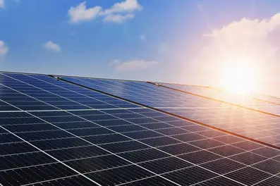 Solarmodule unter blauem Himmel bei Sonnenaufgang, nachhaltige Energiequelle für umweltfreundliche Stromerzeugung.