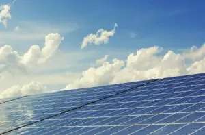 Solarpaneele unter blauem Himmel und Wolken, nachhaltige Energiequelle zur Gewinnung von Solarstrom.